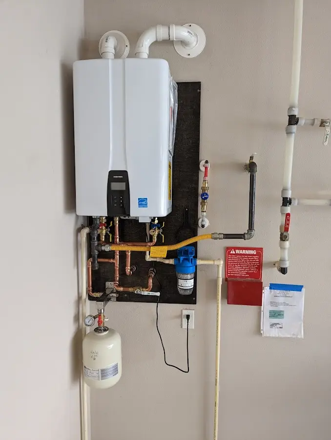 Professional plumber installing copper piping in a Kewanee home